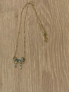 Gold toned Bow Pendant Necklace with Blue Accent
